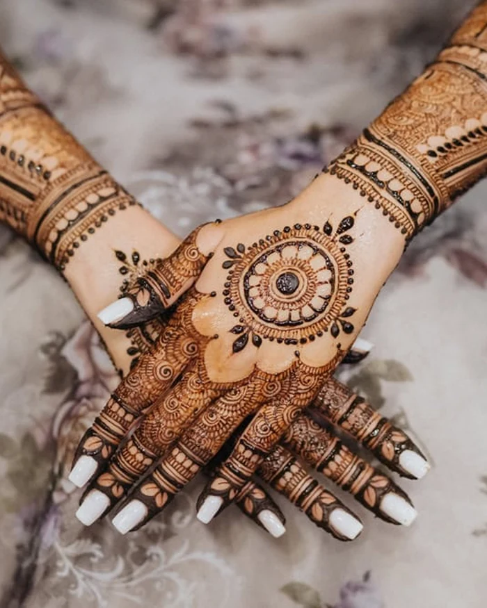 Elaborate henna mehndi sleeve design with a mandala palm motif